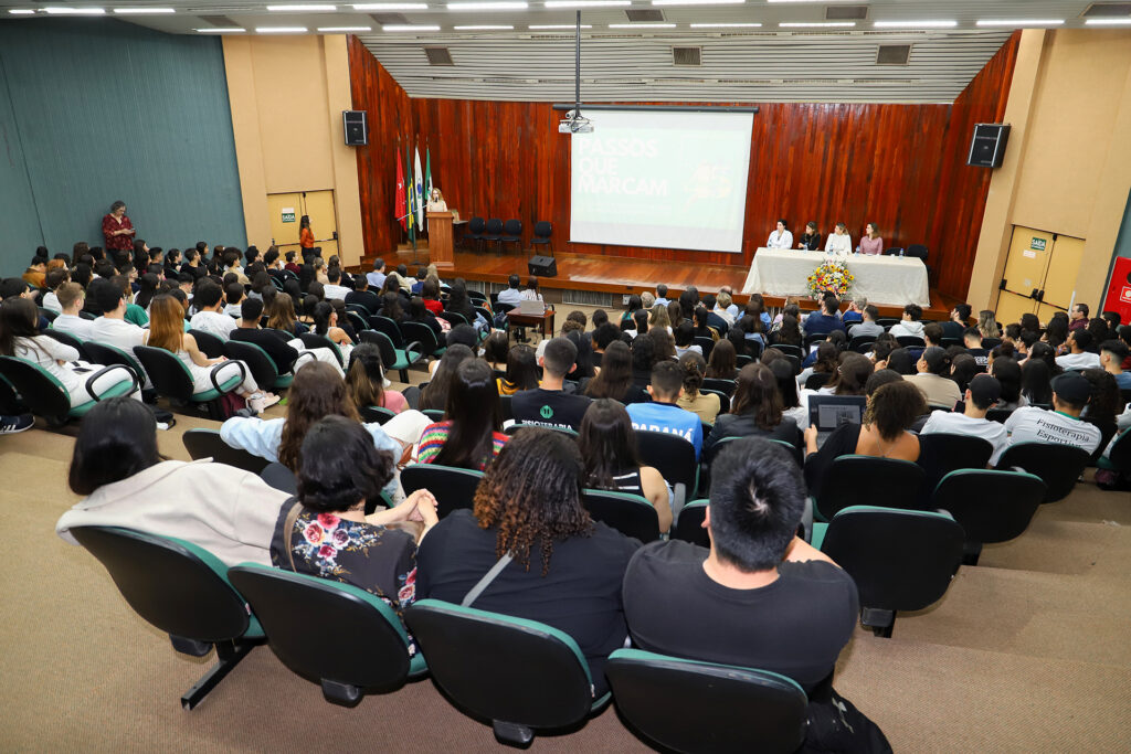 Foto mostrando toda a platéia e os participantes no palco.